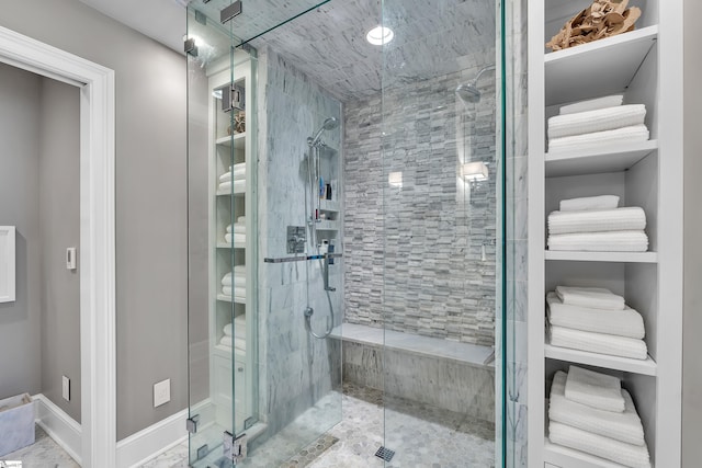 bathroom with a stall shower and baseboards