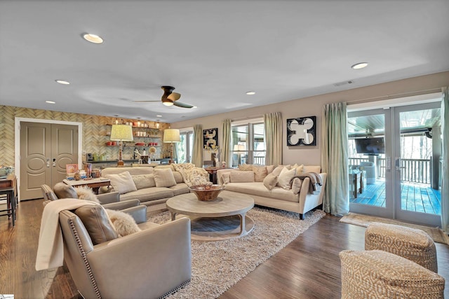 living room with visible vents, dark wood finished floors, wallpapered walls, recessed lighting, and french doors