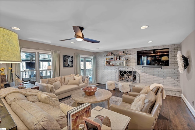 living room with a ceiling fan, dark wood-type flooring, recessed lighting, and a fireplace