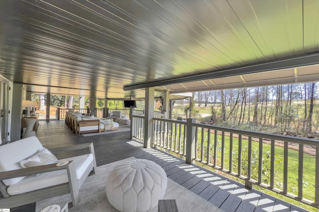 wooden terrace with an outdoor living space