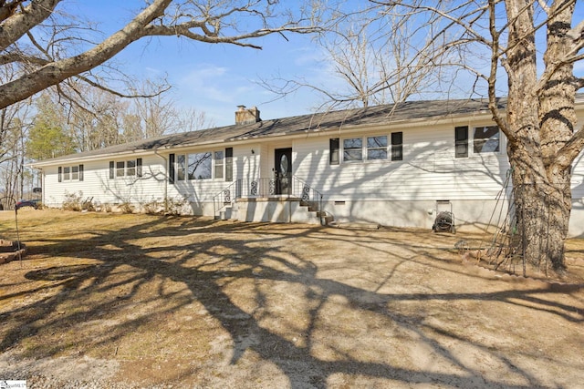 back of house with crawl space and a chimney