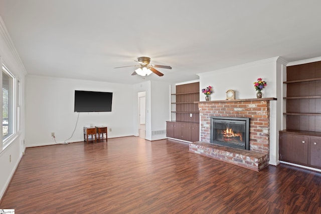 unfurnished living room featuring built in shelves, wood finished floors, a fireplace, ceiling fan, and ornamental molding