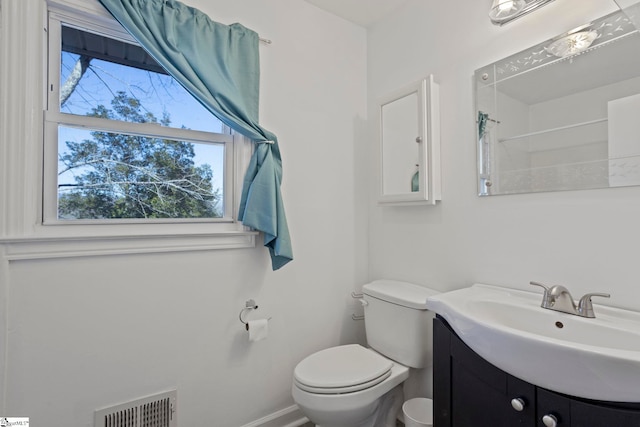 bathroom with visible vents, toilet, vanity, and baseboards