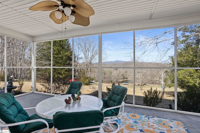 sunroom featuring a mountain view and a ceiling fan