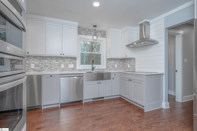 kitchen with dark wood-type flooring, dishwasher, light countertops, wall chimney exhaust hood, and black electric cooktop