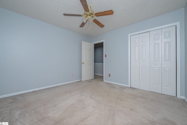 unfurnished bedroom with a closet, baseboards, a textured ceiling, and carpet