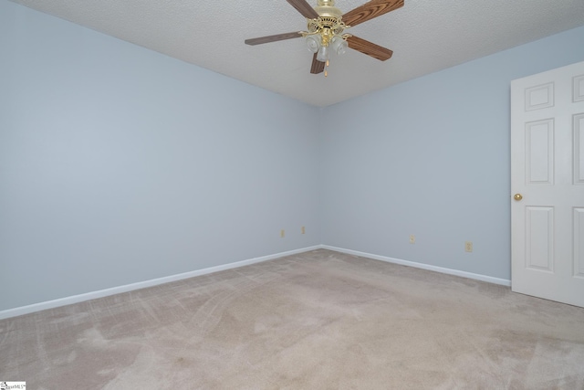 empty room with a textured ceiling, a ceiling fan, baseboards, and light carpet