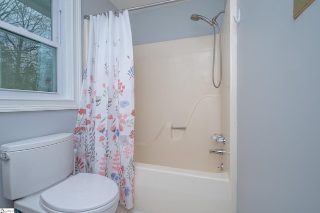 bathroom featuring shower / bath combo with shower curtain and toilet