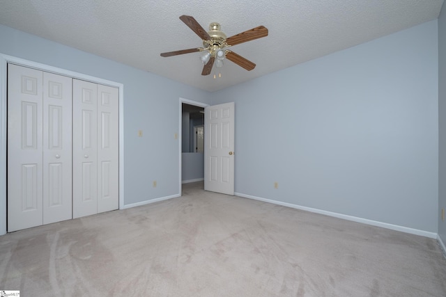 unfurnished bedroom featuring baseboards, carpet, a closet, and a textured ceiling