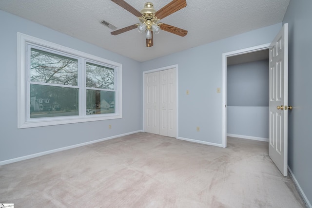 unfurnished bedroom featuring visible vents, baseboards, carpet floors, a closet, and a textured ceiling