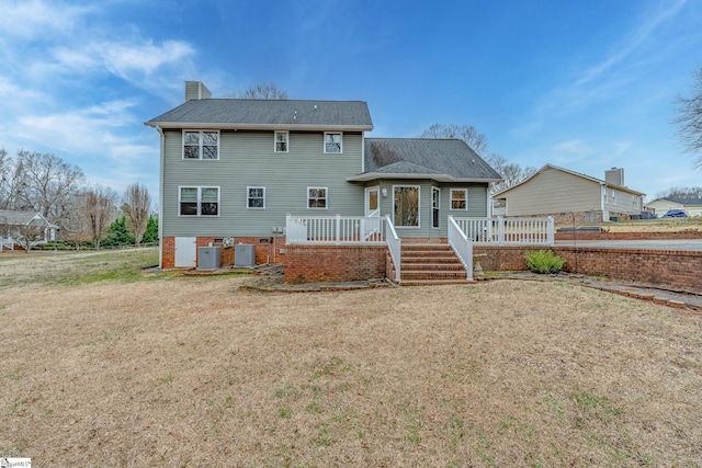 back of property featuring a wooden deck, central AC unit, a chimney, and a yard