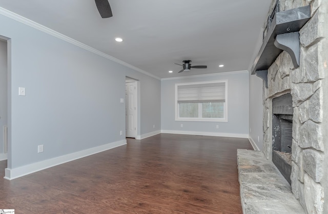 unfurnished living room with dark wood-type flooring, a ceiling fan, a stone fireplace, crown molding, and baseboards