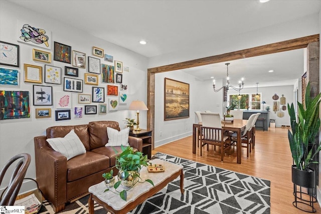 living room featuring recessed lighting, baseboards, an inviting chandelier, and light wood finished floors