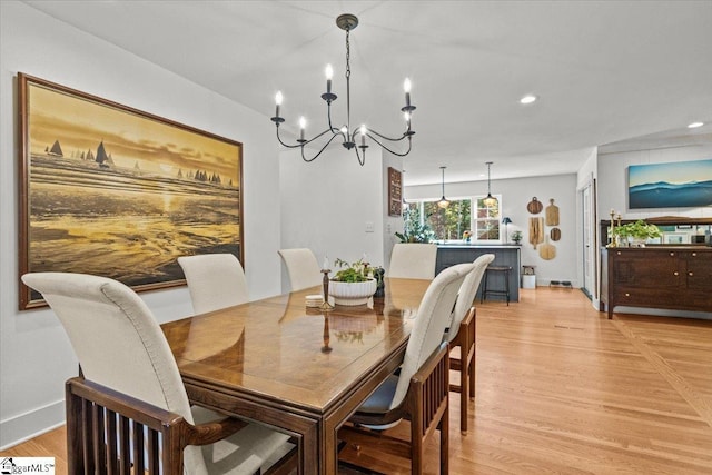 dining room with a chandelier, recessed lighting, light wood-type flooring, and baseboards