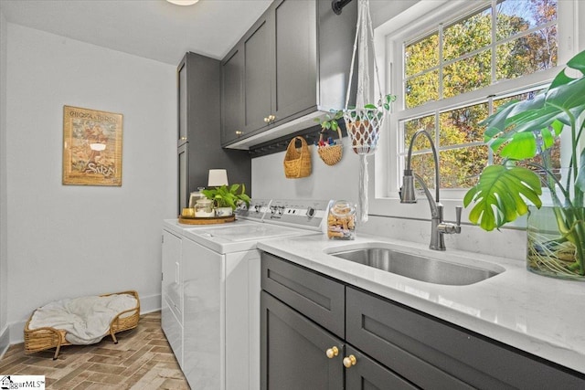 clothes washing area featuring brick floor, cabinet space, independent washer and dryer, and a sink