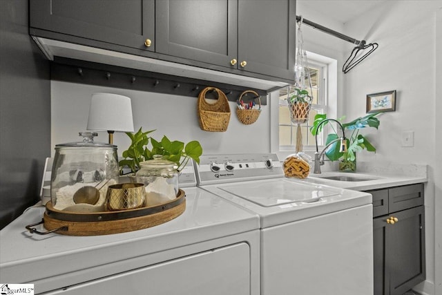 washroom featuring cabinet space, independent washer and dryer, and a sink