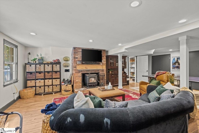 living room featuring recessed lighting, wood finished floors, baseboards, and decorative columns