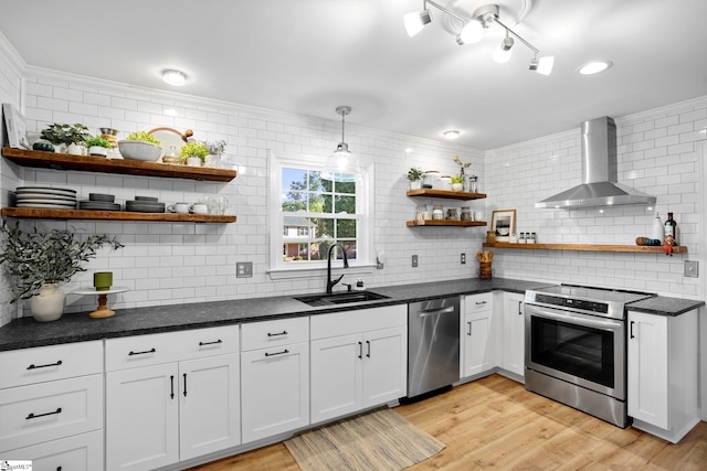 kitchen with a sink, appliances with stainless steel finishes, wall chimney exhaust hood, and open shelves