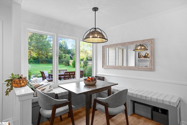 dining space with wood finished floors, a wainscoted wall, and breakfast area