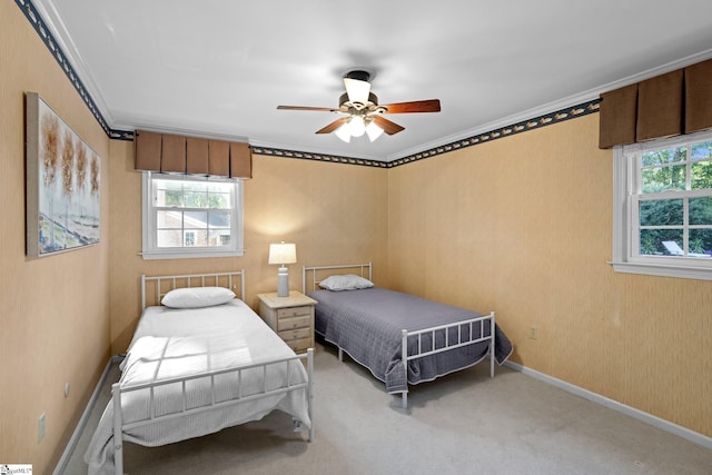 bedroom with a ceiling fan, crown molding, carpet, and baseboards