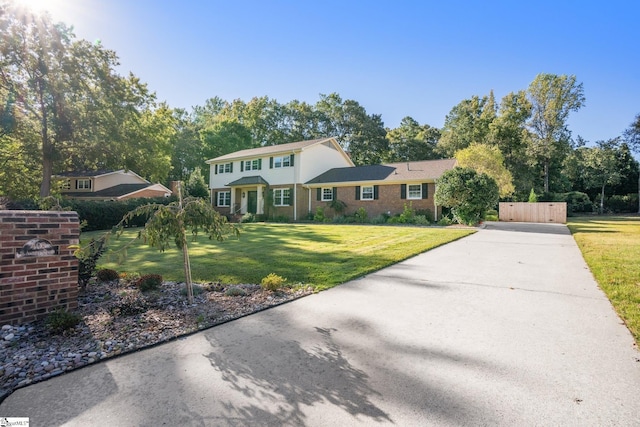 view of front of house with concrete driveway and a front yard