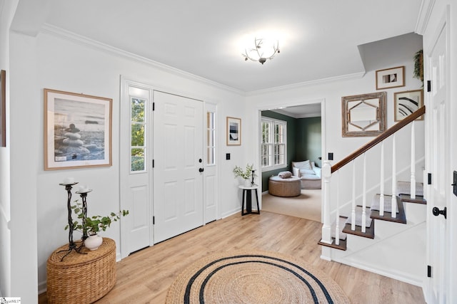 entryway featuring stairway, plenty of natural light, ornamental molding, and wood finished floors