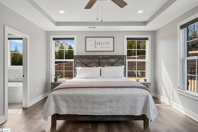 bedroom featuring multiple windows and a tray ceiling