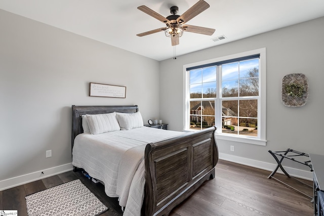 bedroom with visible vents, baseboards, dark wood-style floors, and a ceiling fan