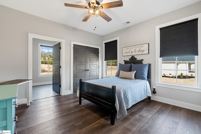 bedroom with dark wood finished floors, visible vents, and baseboards