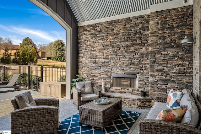 view of patio featuring an outdoor living space with a fireplace and fence