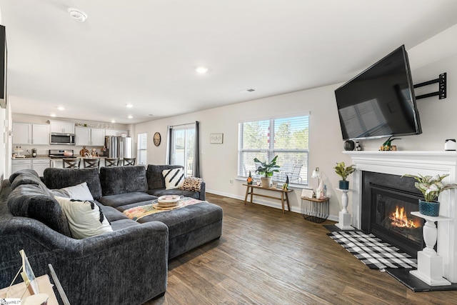 living room featuring visible vents, a fireplace with flush hearth, dark wood-type flooring, recessed lighting, and baseboards