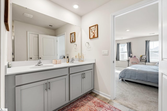 full bath with a sink, baseboards, ensuite bathroom, and double vanity