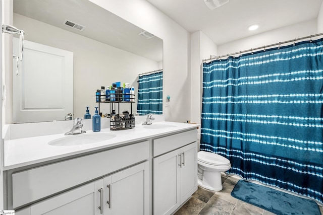 full bath with double vanity, visible vents, toilet, and a sink