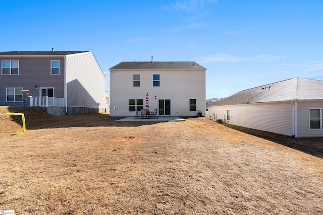 back of property with a patio area and a yard