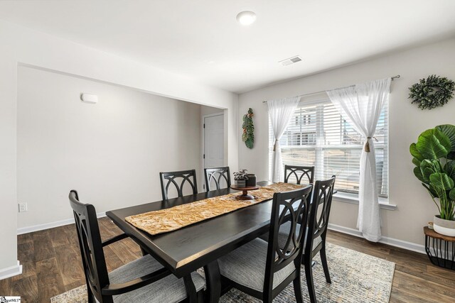 dining space featuring wood finished floors, visible vents, and baseboards