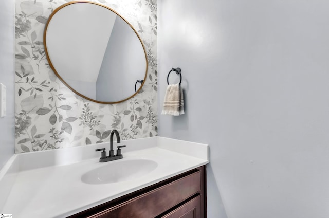 bathroom featuring wallpapered walls and vanity