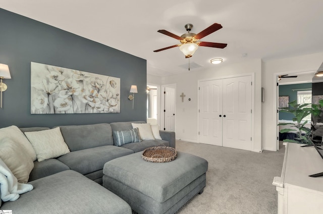 living room featuring light carpet and a ceiling fan