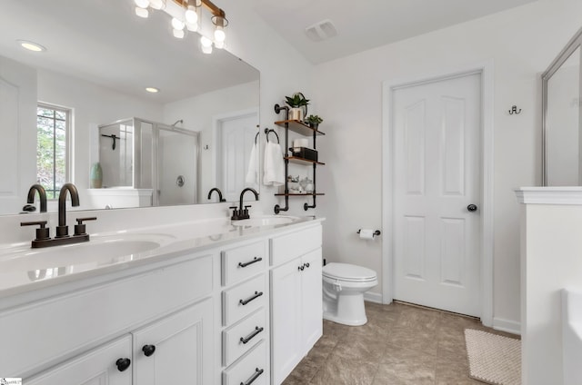 bathroom featuring a sink, toilet, a stall shower, and double vanity