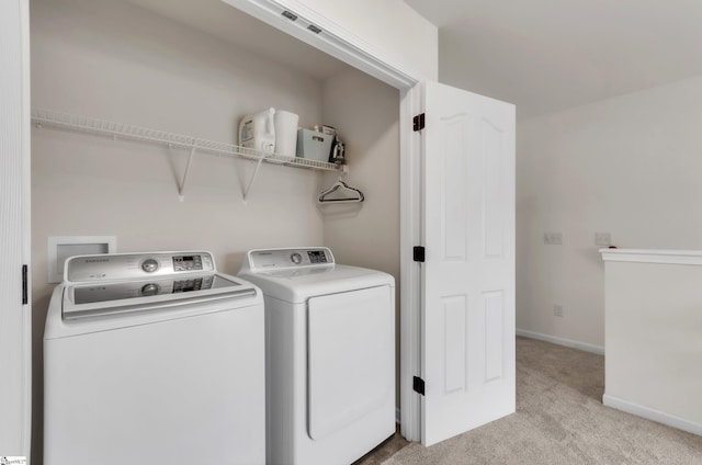 laundry room with washer and dryer, laundry area, light colored carpet, and baseboards