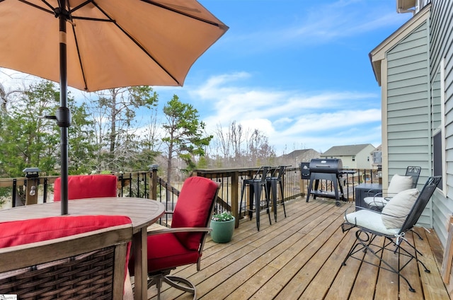 wooden terrace featuring outdoor dining space and a grill