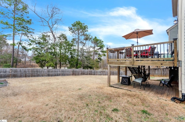 view of yard with a deck, a fenced backyard, and stairs