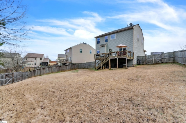 rear view of house featuring a wooden deck, a residential view, a fenced backyard, and stairs