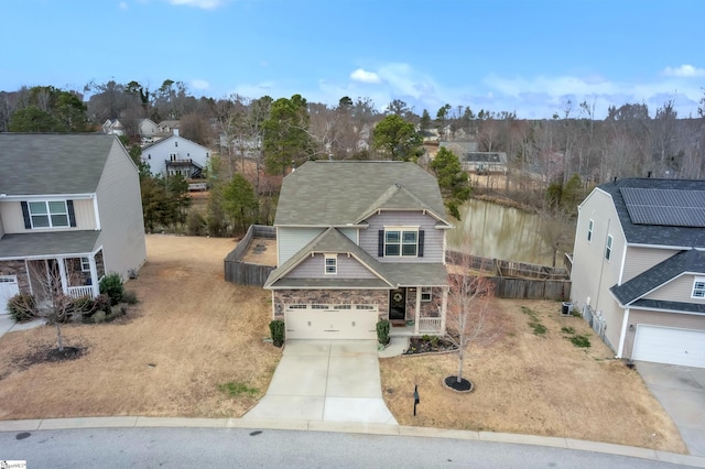 view of front of property with stone siding, fence, covered porch, concrete driveway, and a garage