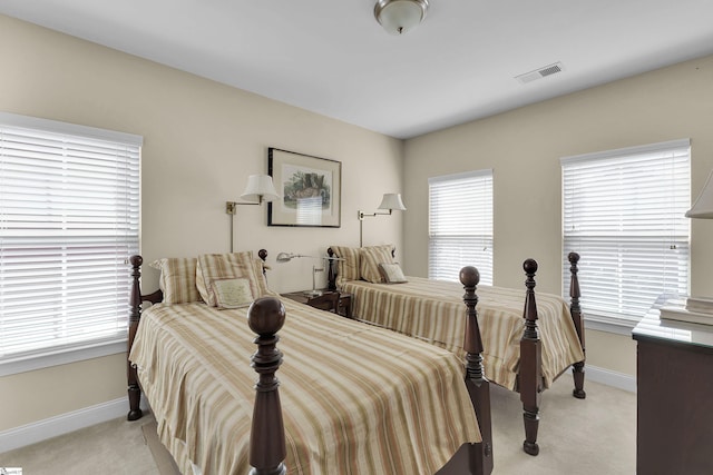 bedroom featuring light carpet, visible vents, and baseboards