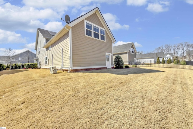 view of side of property featuring central AC and fence