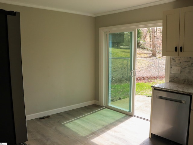 doorway featuring baseboards, wood finished floors, visible vents, and ornamental molding