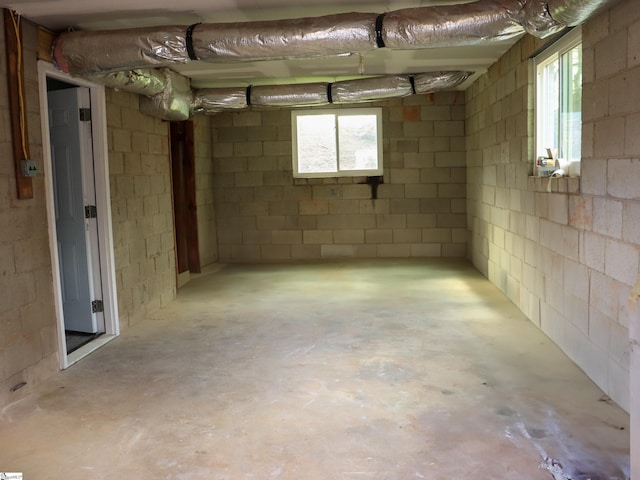 basement featuring concrete block wall and a healthy amount of sunlight