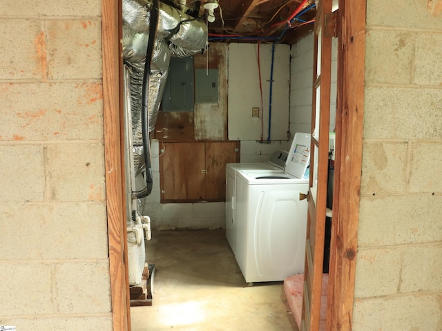 unfinished below grade area featuring electric panel and washing machine and clothes dryer