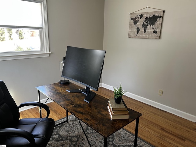 office space with baseboards and wood finished floors