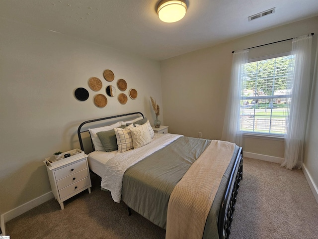 bedroom featuring visible vents, baseboards, and carpet